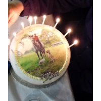 A round birthday cake with an edible photo